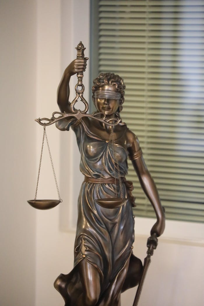 A bronze statue of Lady Justice symbolizing fairness stands indoors.
